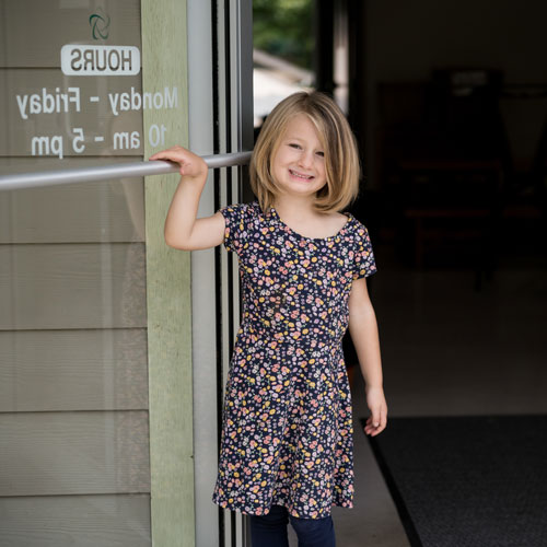 Child holding branch door open